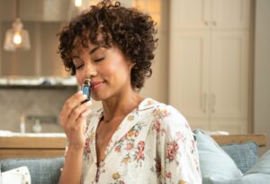 woman smelling a bottle of argan oil