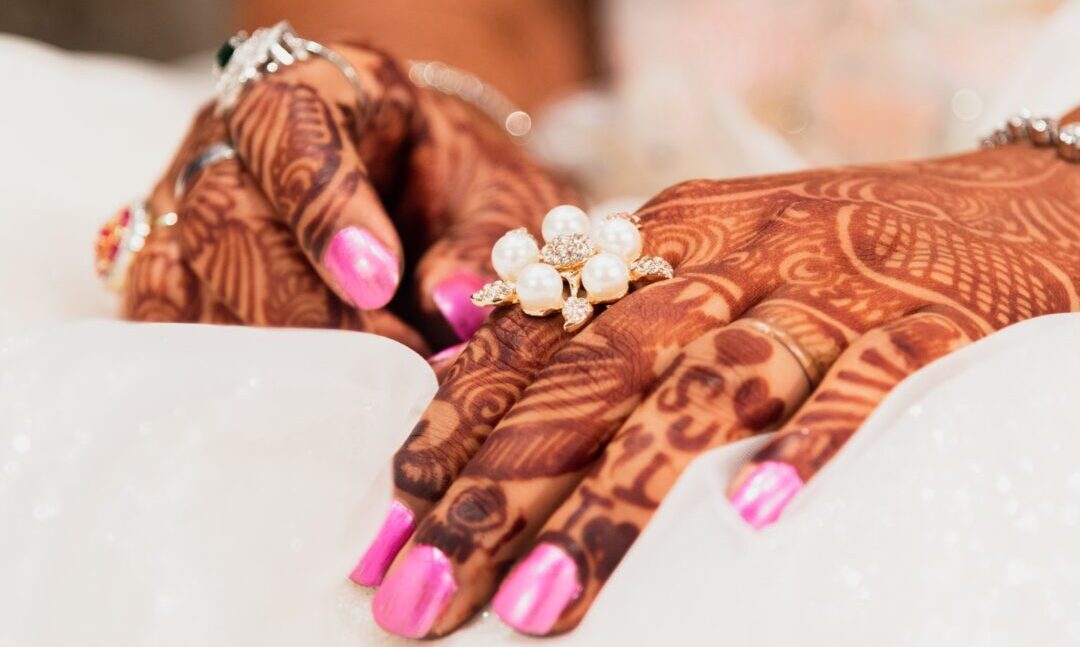 hands with henna and pink nails